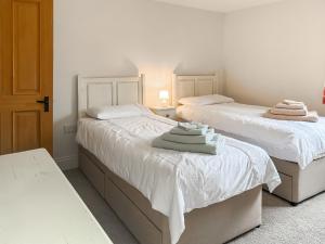 two beds sitting next to each other in a bedroom at The Old Sawmill One - Uk49336 in Plumpton Green