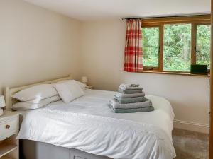 a bedroom with a white bed with a window at The Old Sawmill One - Uk49336 in Plumpton Green
