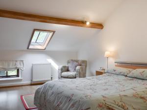 ein Schlafzimmer mit einem Bett und einem Stuhl und einem Fenster in der Unterkunft Forge Masters Cottage in Middlewich