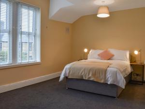 Un dormitorio con una cama y dos ventanas. en Bay View, en Morecambe