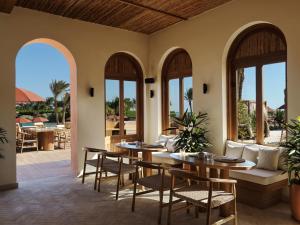 a patio with tables and chairs and a couch at The Chedi El Gouna in Hurghada