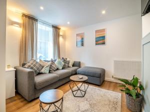 ein Wohnzimmer mit Sofa und Tisch in der Unterkunft High Street Cottage in Treorky