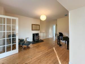 an empty living room with a table and a piano at Holly Croft in Drem