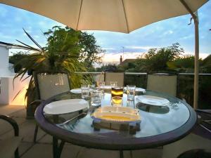 a table with glasses and an umbrella on a patio at Gorsehill House in Poole +5 photos
