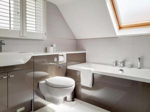 a white bathroom with a toilet and a sink at Gorsehill House in Poole