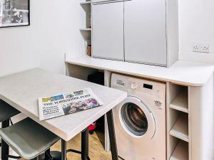 a kitchen with a washing machine and a table at Saltaire Mill Cottage in Saltaire