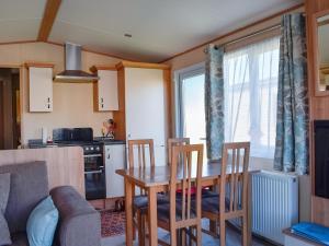 eine Küche mit einem Tisch und Stühlen in einer Küche in der Unterkunft Sunningdale in Westward Ho