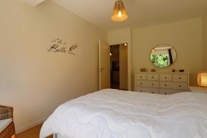 a bedroom with a white bed and a mirror at A5 - Résidence La Montille in Mont-Dore