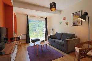 a living room with a couch and a table at A5 - Résidence La Montille in Mont-Dore
