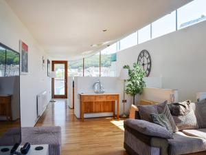 ウエストワード・ホーにあるThe Balconyのソファと壁掛け時計のあるリビングルーム