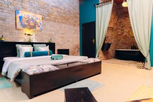 a bedroom with a large bed and a bath tub at Ibuye Villa Holiday Home in Nyakinama