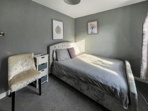 Un pequeño dormitorio con una cama y una silla. en Fleet Townhouse, en Gatehouse of Fleet