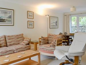 a living room with a couch and a table at Meadowcroft Cottage in Bowness-on-Windermere