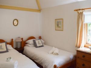 a bedroom with two beds with a cat laying on them at Shadycombe Lodge in Salcombe +22 photos