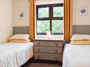 a bedroom with two beds and a window at Hey Ho Cottage in Whitby