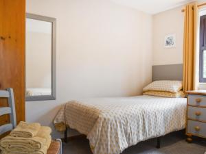 a small bedroom with two beds and a mirror at Hey Ho Cottage in Whitby