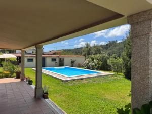 a swimming pool in the yard of a house at Oliveira's Little House in Caminha