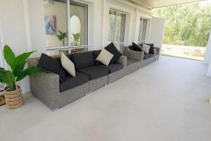 een woonkamer met een bank en een groot raam bij Perfection in Pallarenda With Pool & Studio Apt in Pallarenda