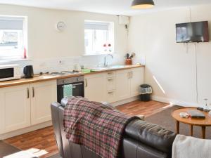 a living room with a couch and a kitchen at Swan's Nest - Uk43545 in Belford