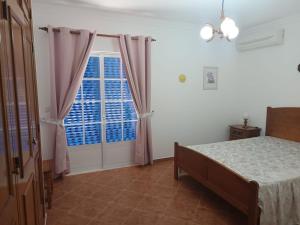 a bedroom with a bed and a window at Moradia 41 in Altura
