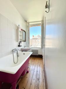 a bathroom with a tub and a sink and a window at Maison Blanc de blanc - Guest Room in a Family Home in Le Mesnil-sur-Oger