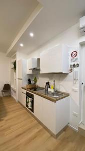una cucina con mobili bianchi e un lavello di L'Ulivo in Centro a Bari