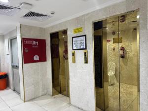 a row of elevators in a building with a sign at فندق المقام الذهبي الروضة - Maqam Aldhahabi Hotel Al Rawda in Al Khansāk