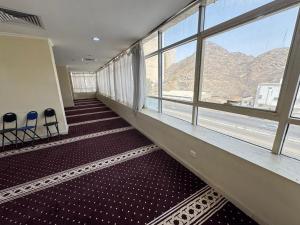 an empty hallway with chairs and windows in a building at فندق المقام الذهبي الروضة - Maqam Aldhahabi Hotel Al Rawda in Al Khansāk