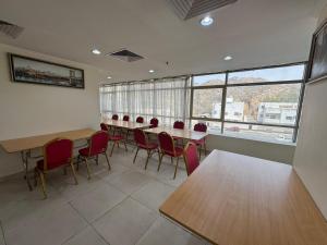 a conference room with tables and chairs and windows at el maqam el zahbe in Al Khansāk