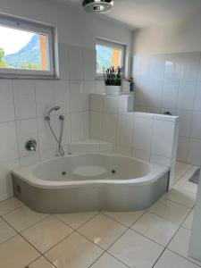 a large white tub in a bathroom with a window at Vacation home Oxy in Ferlach +28 photos