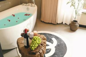 un bagno con una bottiglia di vino e uva su un tavolo di Dawnscape snowmountain viewing Courtyard - Baisha old town a Lijiang