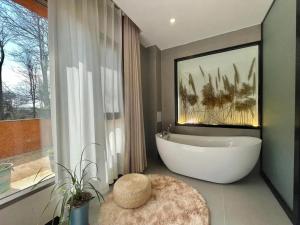 een badkamer met een bad en een groot raam bij Dawnscape snowmountain viewing Courtyard - Baisha old town in Lijiang