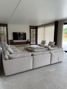 a large living room with a large couch and chairs at Casa Atlântica 26 in Troia +30 photos