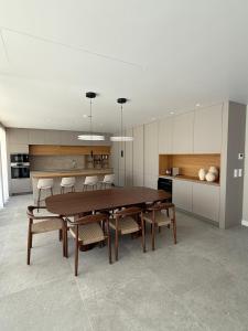 a dining room with a table and chairs and a kitchen at Casa Atlântica 26 in Troia