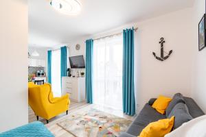 a living room with a couch and a yellow chair at APARTAMENT NADMORSKI in Rowy