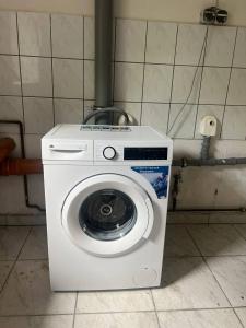una lavatrice bianca in una stanza con un muro di Spacious Flat with 3 bedooms for 5-8 guests a Zeitz