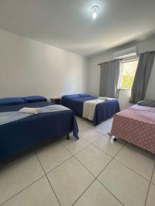 ein Hotelzimmer mit zwei Betten und einem Fenster in der Unterkunft Próx a orla, 14 pessoas, ar condicionado e garagem in Petrolina