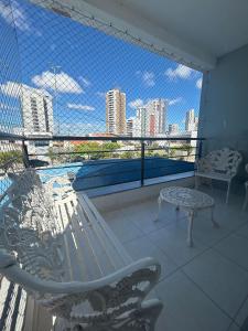 ein Balkon mit einer Bank und Blick auf die Stadt in der Unterkunft Próx a orla, 14 pessoas, ar condicionado e garagem in Petrolina