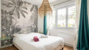 a bedroom with a bed with a pink hat on it at Albatros in Saint-Nazaire