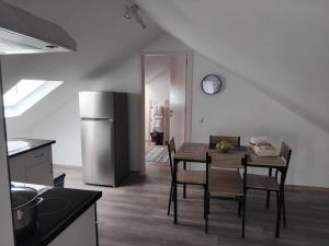 a kitchen with a table with chairs and a refrigerator at MM House in Bicas