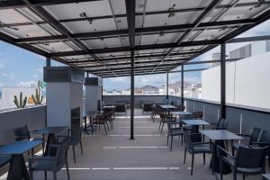 a restaurant with tables and chairs on a roof at Hotel LIVVO La Escarlata in Las Palmas de Gran Canaria