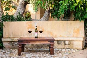 a wooden table with two glasses of wine on it at Il-Wileg B&B in Qala