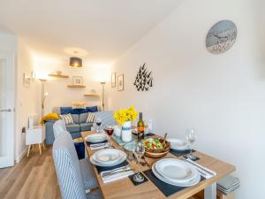 a dining room and living room with a table and chairs at Blue Skies in Carew