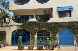 a building with blue doors and ivy on it at Résidence NATANGUE 1 - Studio La Bella in Sali Nianiaral