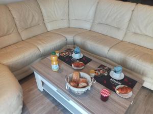 a couch with a coffee table with food on it at Au Fil de l'Eau in Château-Gontier