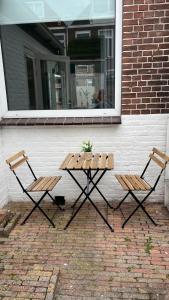 a picnic table and two chairs in front of a building at Large Family House Alkmaar in Alkmaar