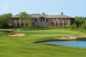 uma vista para um campo de golfe com um edifício em The Glen Club em Glenview