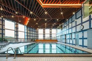 a large swimming pool in a building with windows at OREA Hotel Pyramida Praha in Prague