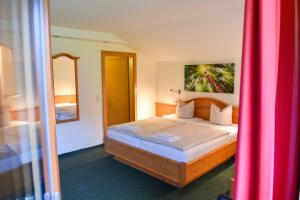 a hotel room with a bed with a pink curtain at Salzburger Dolomitenhof in Annaberg im Lammertal +19 photos