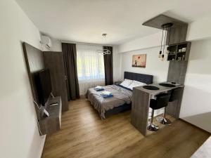 a small bedroom with a bed and a desk at Royal Apartmani 3 in Paraćin